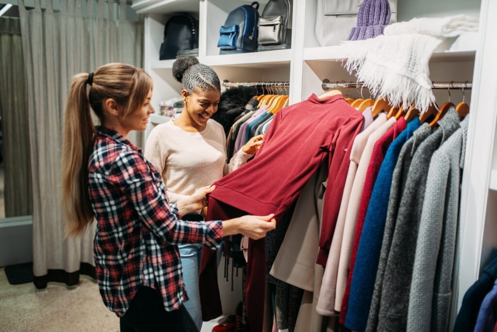 Two girlfriends choosing clothes in shop, shopping